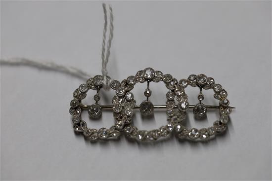 A 1920s white gold and diamond set interlocking triple circle openwork drop brooch,